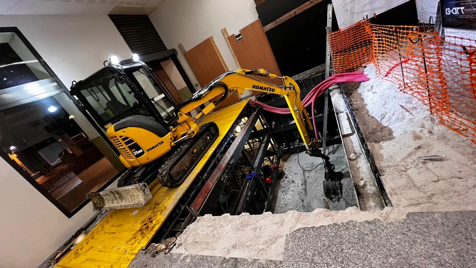 Mini-pelle dans une fouille blindée, à l’intérieur d’un bâtiment